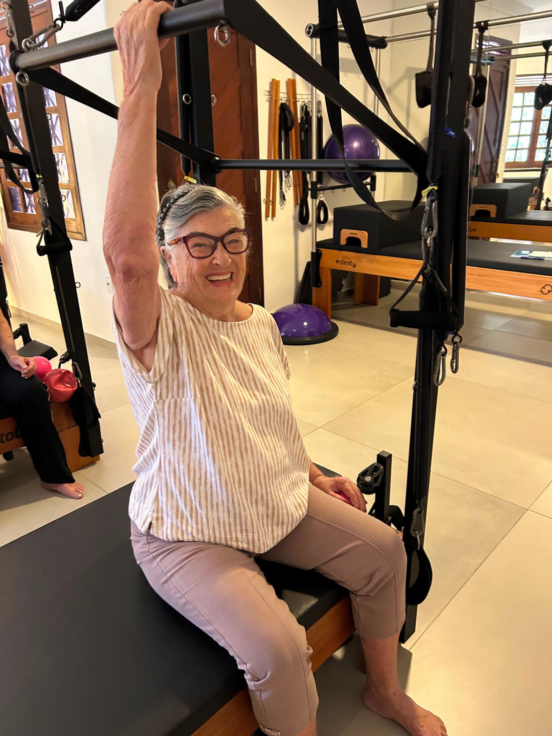 Aluna sorrindo durante exercício no aparelho Cadillac